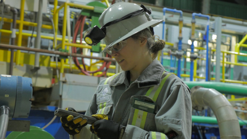 A female technician operating equipment in a plant